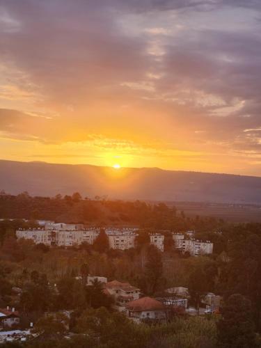 キリヤット・シュモナにあるדירה Be Coliving קרית שמונהの建物や木々が並ぶ街の夕日