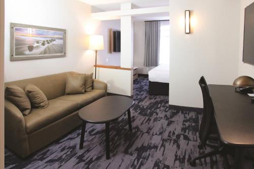 a hotel room with a couch and a table and a bed at Fairfield Inn & Suites by Marriott Charleston Airport/Convention Center in Charleston