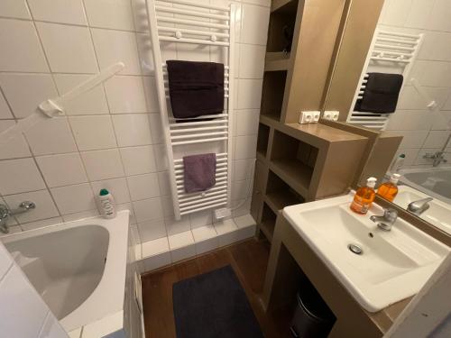 une salle de bain avec un lavabo, une baignoire et des toilettes dans l'établissement Appartement Atypique, centre de Paris, à Paris