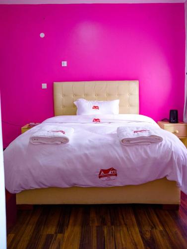 a pink bedroom with a bed with a pink wall at Destination code 254, Nyeri in Nyeri