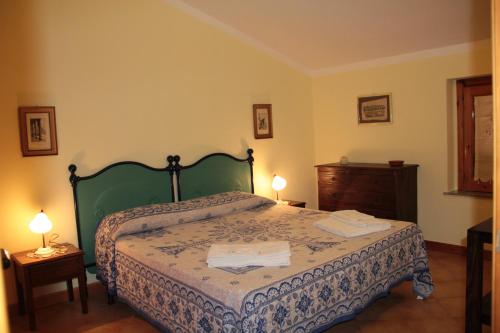 a bedroom with a bed with two lamps on it at Uliveto in Gioiosa Marea