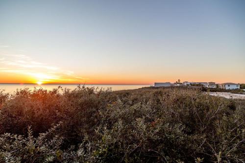 a sunset over a beach with condos in the background at Sojourn's Sanctuary Condo Vitamin Sea Sleeps 6 in Virginia Beach