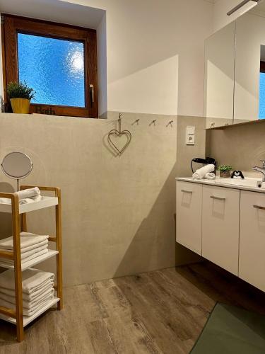 a kitchen with white cabinets and a heart on the wall at Landhaus Knaus in Leutasch