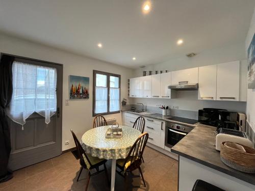 - une cuisine avec une table, une table et des chaises dans l'établissement Villa des Avocettes, au Crotoy