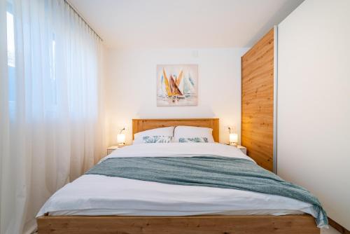 a bedroom with a large bed with a wooden headboard at Apartment ILUX-1 in Novigrad Dalmatia