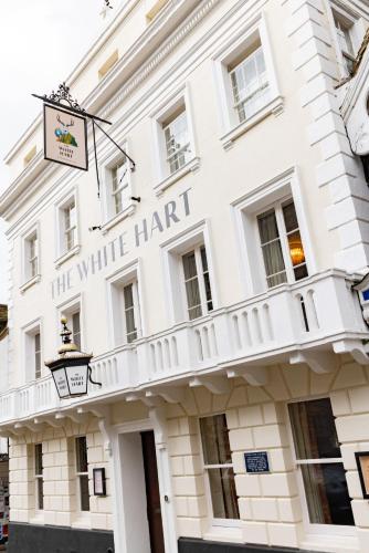 a white building with a white harart sign on it at The White Hart - A Heartwood Inn in Lewes