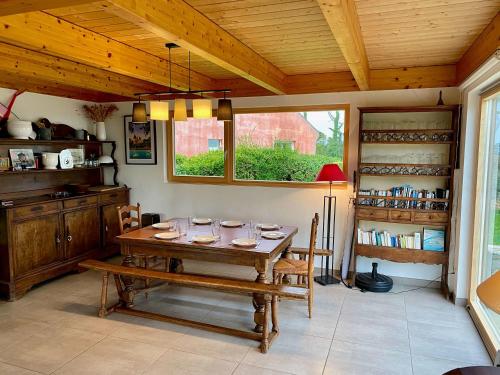 une salle à manger avec une table en bois et une fenêtre dans l'établissement House with sea view and large garden for 8 people, à Plougasnou
