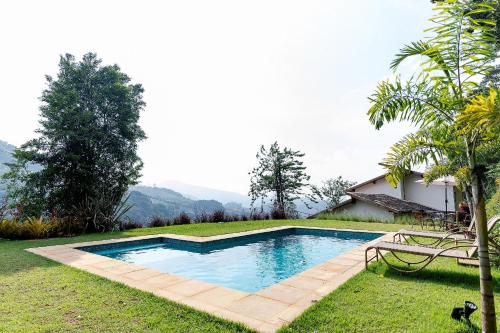 a swimming pool in the yard of a house at Refúgio na Serra - Casa 3 suítes em Condomínio in Pedro do Rio