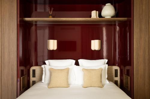 a bed with white sheets and pillows in a room at HIGHSTAY Maisons - Boétie in Paris