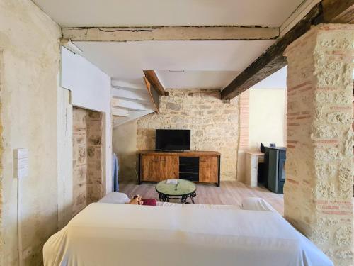 Cette chambre comprend un lit, une télévision et une table. dans l'établissement Maison Familiale du Quercy, à Montpezat-de-Quercy