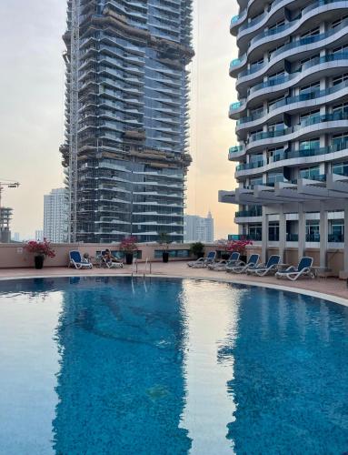 a large swimming pool in front of two tall buildings at Cosy Studio in Marina in Dubai