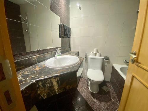 a bathroom with a sink and a toilet at Cosy Studio in Marina in Dubai