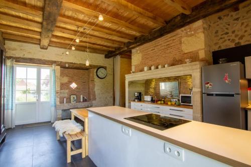 une cuisine avec un comptoir et un réfrigérateur dans l'établissement Le grand nid, à La Maurandie
