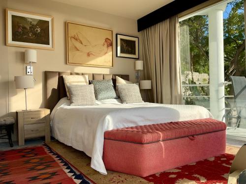 a bedroom with a large bed with a red ottoman at Marbella Boutique Art suites in Marbella