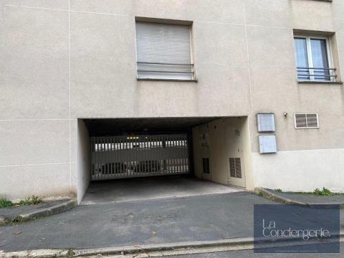 un immeuble avec un garage avec un portail dans l'établissement Le Carmélite - Poitiers Futuroscope - proche gare - LaConciergerie, à Poitiers