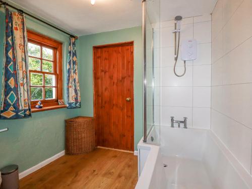 a bathroom with a shower and a bath tub at Rose Cottage in Falmouth