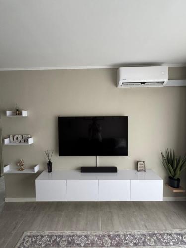 a living room with a white entertainment center with a flat screen tv at Motswedi Place 1 Bed Apartment M10- Managed by Pulafela Prop Pty Ltd in Gaborone