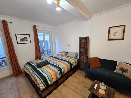 une chambre avec un lit et un canapé dans l'établissement Confortable près des transports, à Paris