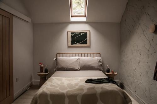 ein Schlafzimmer mit einem Bett und einem Fenster darüber in der Unterkunft The Bothy - A secluded and romantic rural retreat in Llanddyfnan