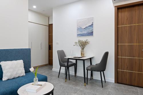 a living room with a blue couch and a table at 22Land Cosmos Hotel in Hanoi