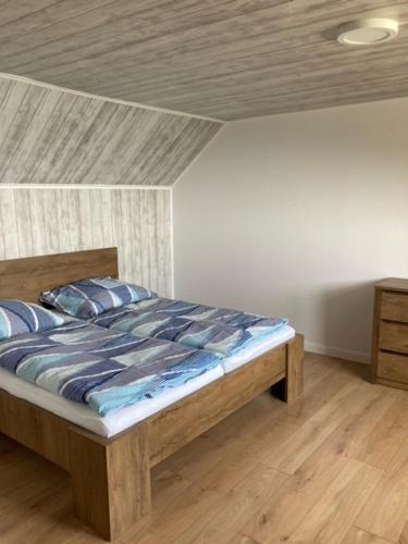 a bedroom with a wooden bed with blue pillows at chata Viňanka in Michalovce
