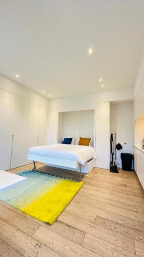 a bedroom with a bed and a yellow rug at Studio Fischer à la Pétrusse 002 in Luxembourg