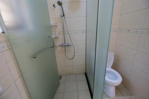 a bathroom with a shower and a toilet at The Residence at Lunyo in Entebbe