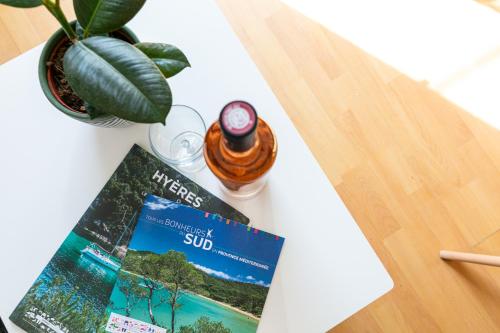 un livre assis sur une table à côté d'une usine dans l'établissement La Maison de Papou, charmante maison de village avec vue mer idéalement située à la Madrague, à Hyères