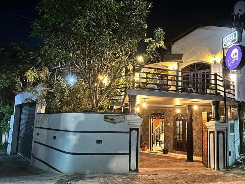 una casa con un árbol delante de ella por la noche en Enderamulla Casual Home, en Wattala