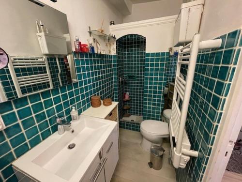 La salle de bains est pourvue d'un lavabo, de toilettes et de carrelage bleu. dans l'établissement appartement loft dans la Vieille Ville, à Sainte-Maxime