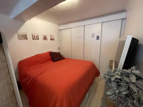 une chambre avec un lit rouge et une télévision dans l'établissement appartement loft dans la Vieille Ville, à Sainte-Maxime