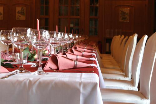 a long table with wine glasses and red napkins at Hotel Zur Krone in Ronneburg