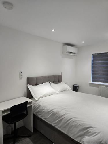 a bedroom with a bed with a desk and a chair at Luxury and stylish 3 bedroom house or Apartment in Greenhithe - Available for booking as individual Room or as a Whole apartment - 11mins walk to Greenhithe Train Station, 7 mins drive to Bluewater shopping mall in Greenhithe