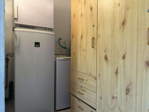 Il comprend une cuisine avec un réfrigérateur et un mur en bois. dans l'établissement Appartement 2P, cabine, 250m plage, loggia calme - FR-1-229D-146, à Fleury