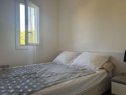 - un lit non aménagé dans une chambre avec fenêtre dans l'établissement Appartement 2P, cabine, 250m plage, loggia calme - FR-1-229D-146, à Fleury