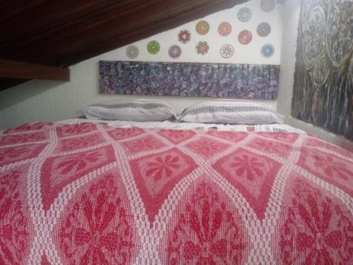 Una cama con un edredón rojo y blanco. en Atelier House, en Florianópolis