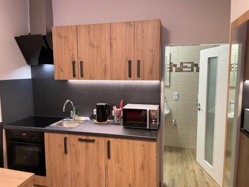a kitchen with wooden cabinets and a microwave at Penzion Netolice in Netolice