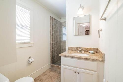 a white bathroom with a sink and a mirror at 9 Bedroom Oceanfront Beach House in Debordieu in Pawleys Island