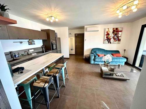 Il comprend une cuisine et un salon avec un canapé bleu. dans l'établissement Superbe T3 front de mer au centre de Propriano, à Propriano