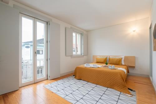 a bedroom with a bed and a large window at Lovely Apartments in the Heart of Guimarães by HostWise in Guimarães
