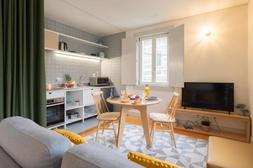 a kitchen and a living room with a table and chairs at Lovely Apartments in the Heart of Guimarães by HostWise in Guimarães
