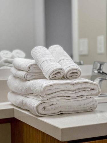 a stack of towels sitting on a counter in a bathroom at Beachside Luxury Apartment I Free Parking in Los Angeles