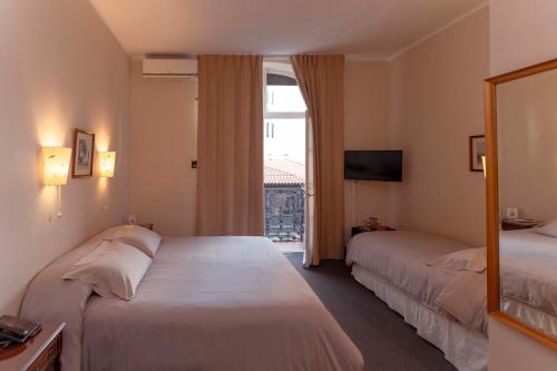 a hotel room with two beds and a window at Hotel Colonial Salta in Salta
