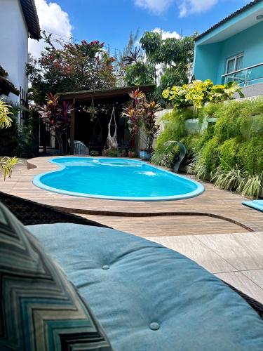 a large blue swimming pool in a yard at Villa Bangalu Exclusiva para Adultos in Porto De Galinhas