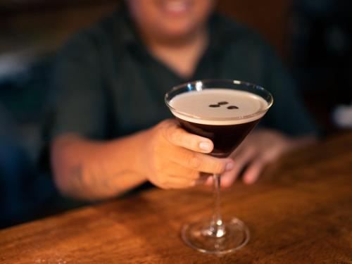 a person is holding a drink in a glass at Posada Amazonas Lodge in Tambopata