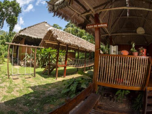 a hut with a hammock in front of it at Posada Amazonas Lodge in Tambopata