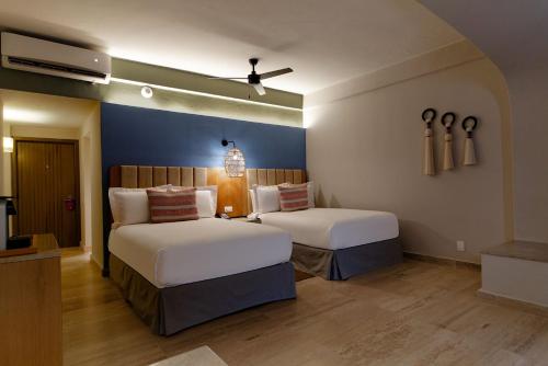 a bedroom with two beds and a blue wall at Camino Real Acapulco Diamante in Acapulco