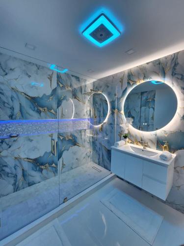 a bathroom with a marble wall with a sink and a mirror at Naples Gem Near Beach Heated Pool & BBQ in Naples