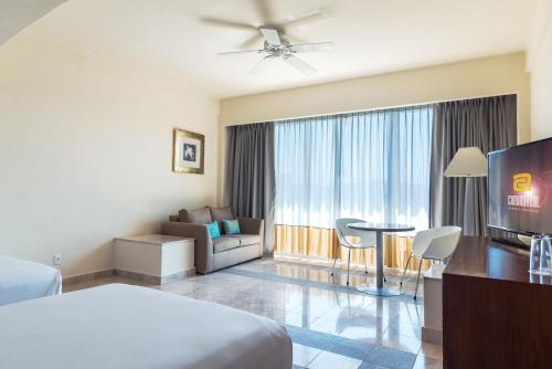 a hotel room with a bed and a living room at Camino Real Acapulco Diamante in Acapulco
