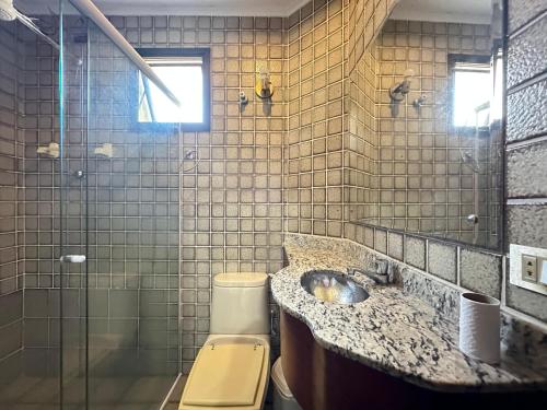 a bathroom with a sink and a toilet and a shower at Ap 3 quartos praia grande vista pro mar área nobre in Ubatuba
